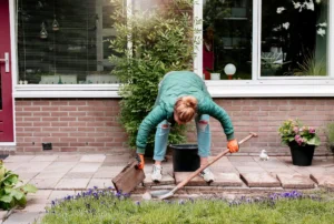 Frau entfernt Pflastersteine